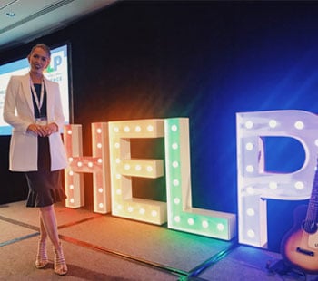 Anja Christoffersen standing in front of a help sign