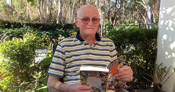 David sitting in the garden reading a book